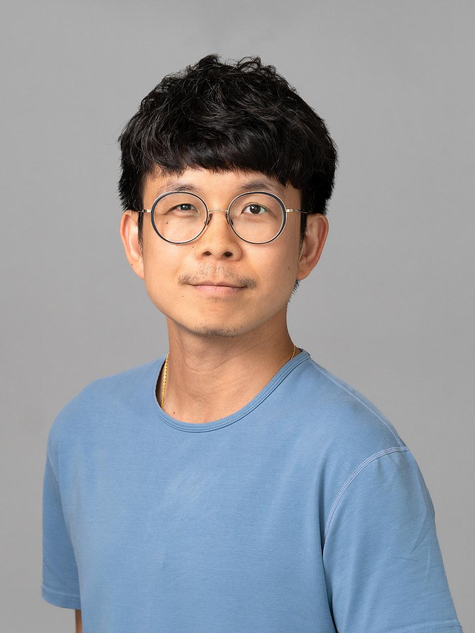Photo of a man, Dr. Wasawat Vutthikraivit, with short dark hair and glasses wearing a blue shirt smiling at the camera.