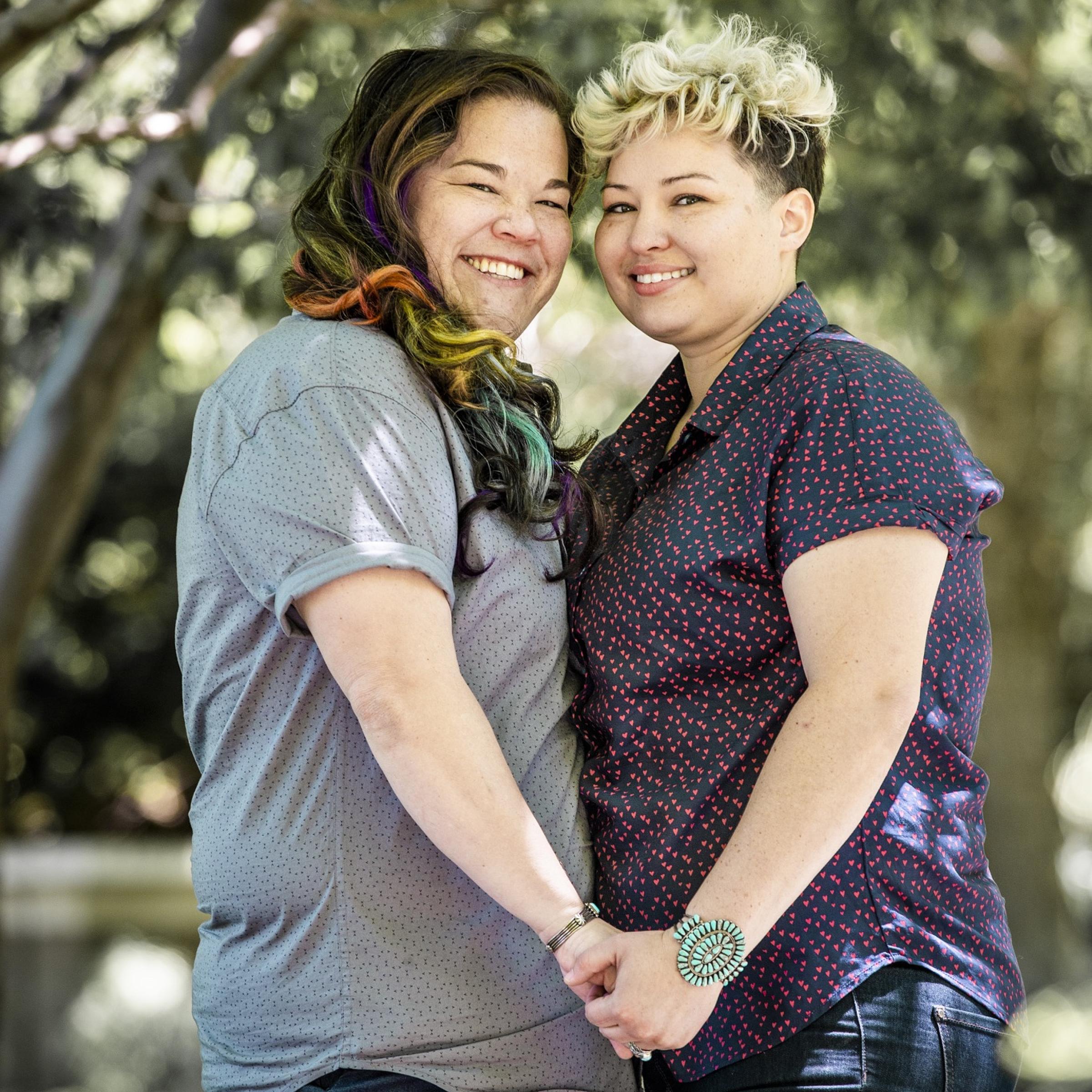 Celeste and Keisha smiling and holding hands