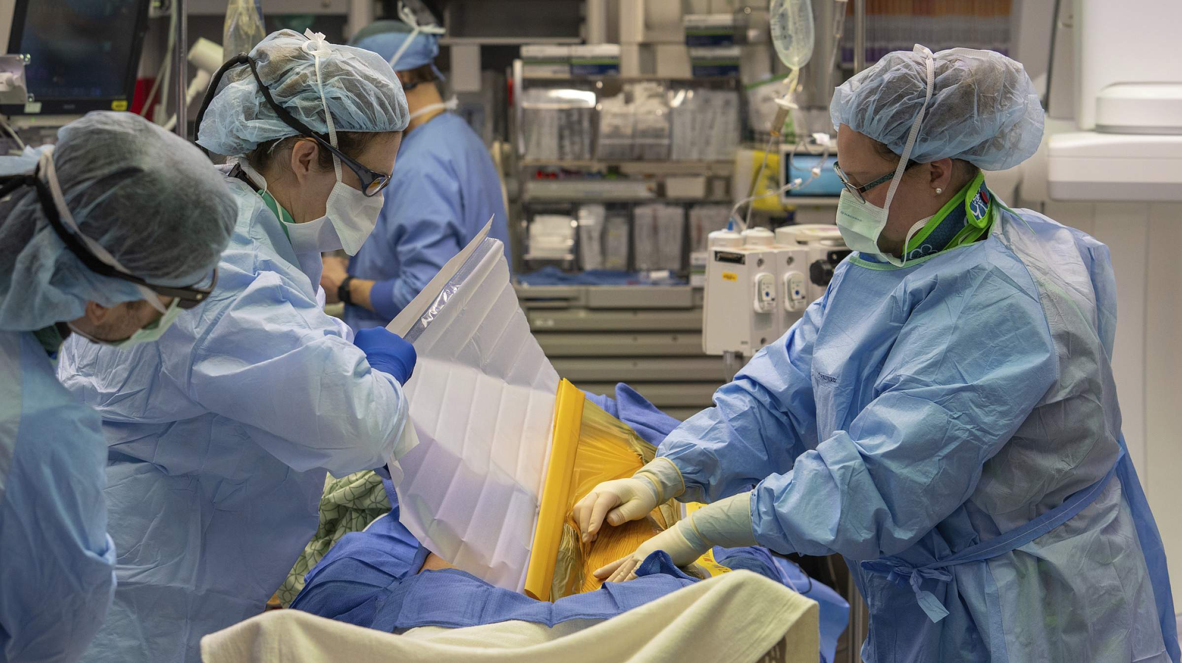 Surgeons performing an aortic aneurysm treatment