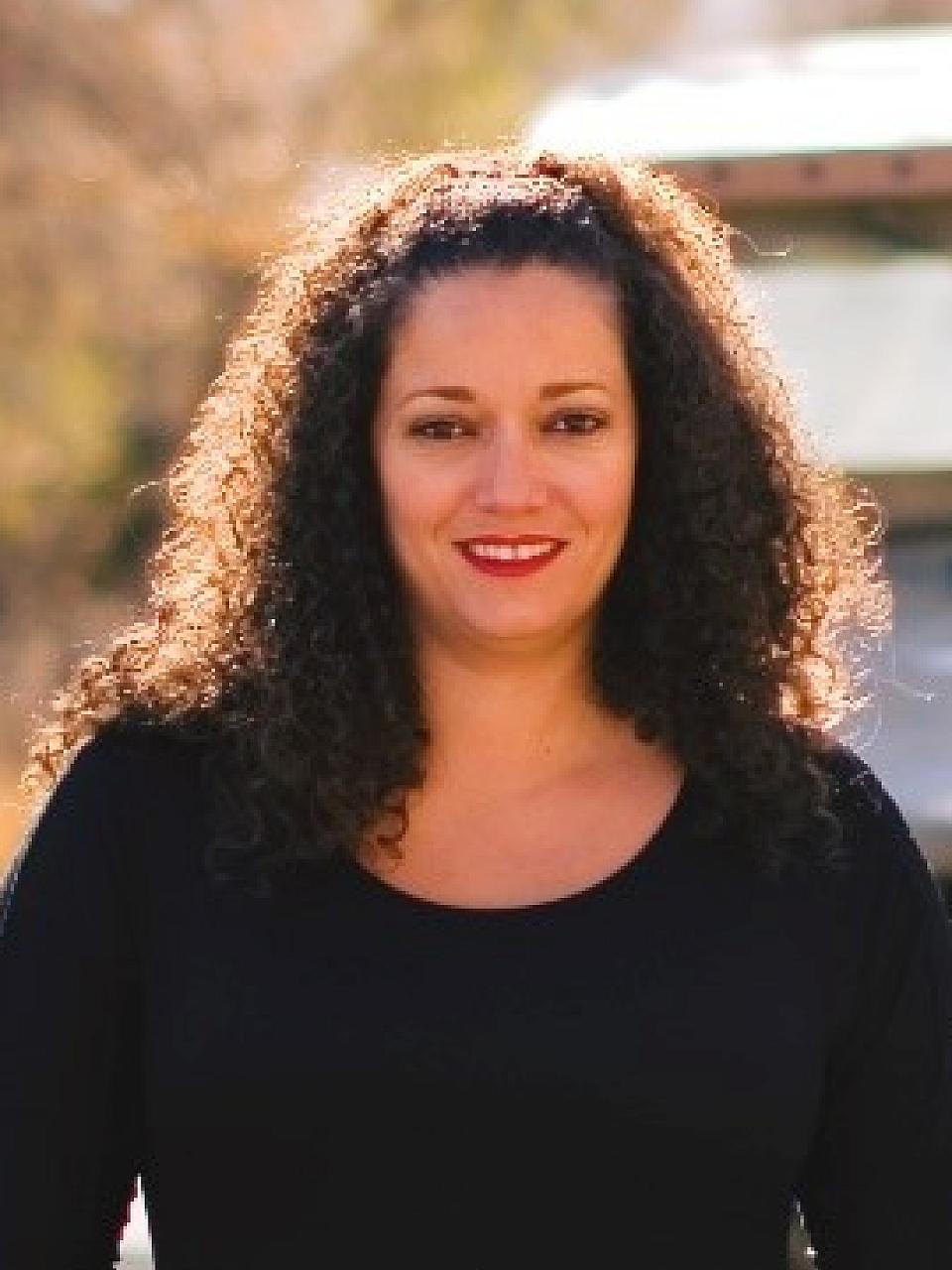 Women with dark curly hair and a black t-shirt