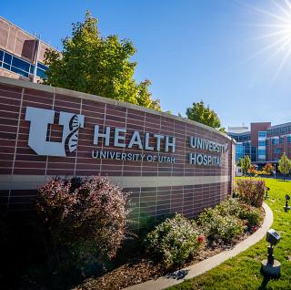 U of U hospital sign with the hospital in the background