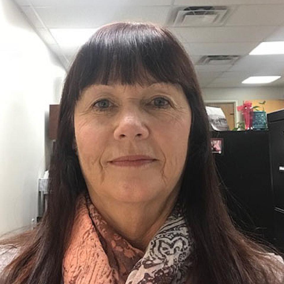 Caucasian woman with straight dark brown hair and bangs