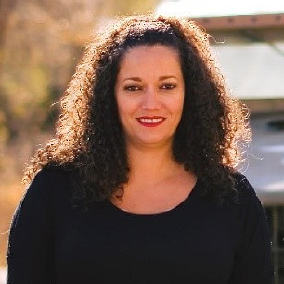 Women with dark curly hair and a black t-shirt