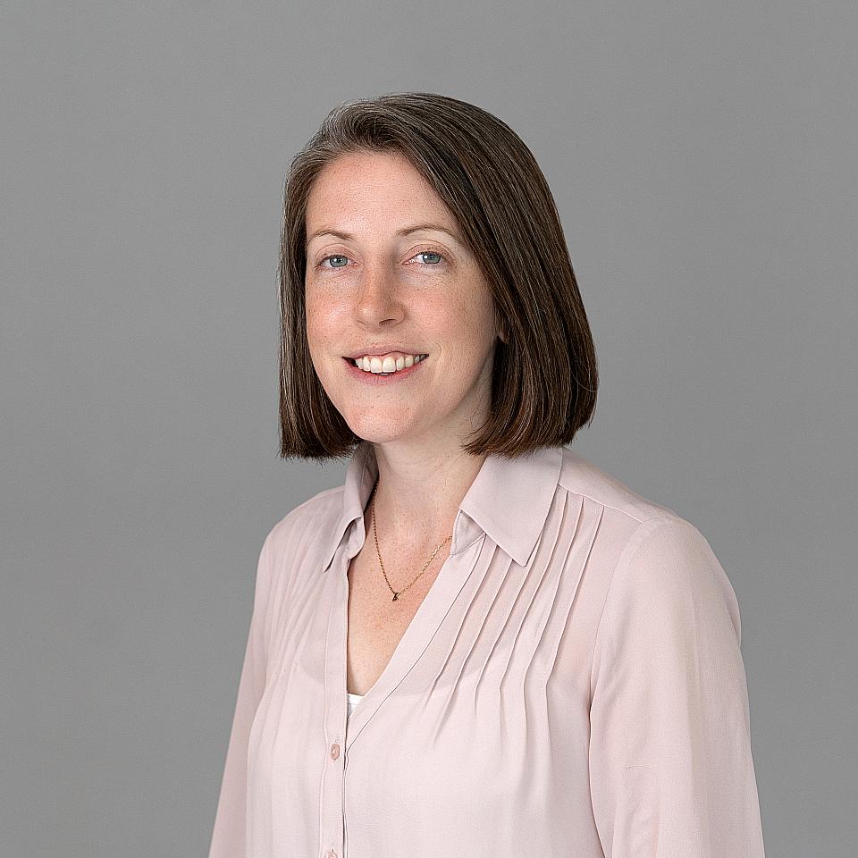 Photo of a woman, Dr. Andrea Keithler, with dark hair and a light pink shirt smiling at the camera.