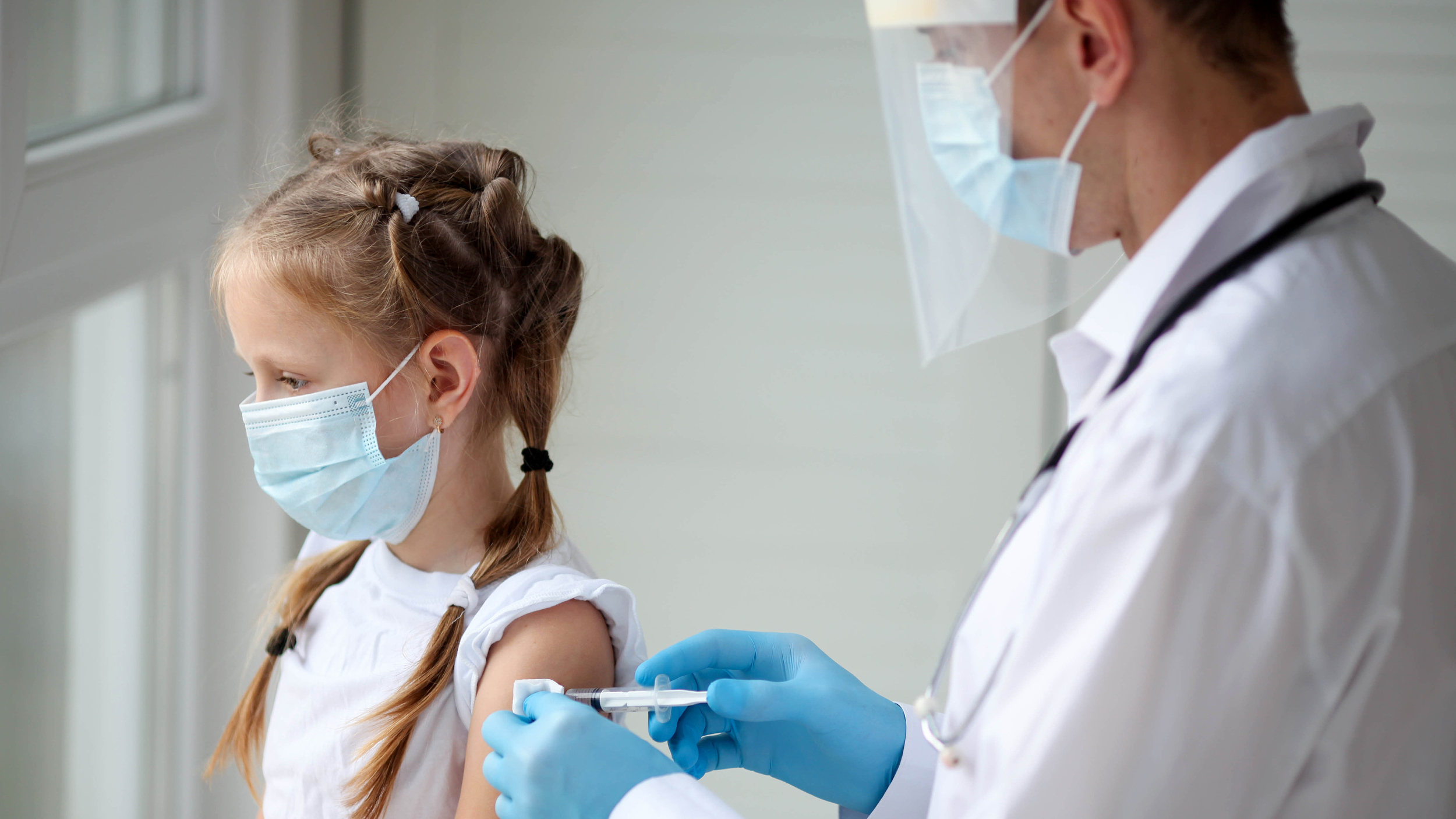 Doctor administering shot to child