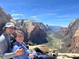 Residents sitting at a canyon and smiling at the camera