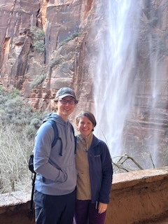 Two people standing in front of a waterfall
