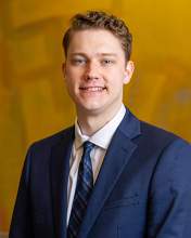 Photo of James Trippett wearing a suit coat and tie