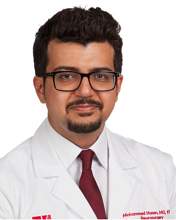 Mohammed Hasen wearing his University of Utah branded white coat, a white shirt, and a red tie