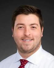 Professional photo of Jordan Roach wearing a white shirt and tie