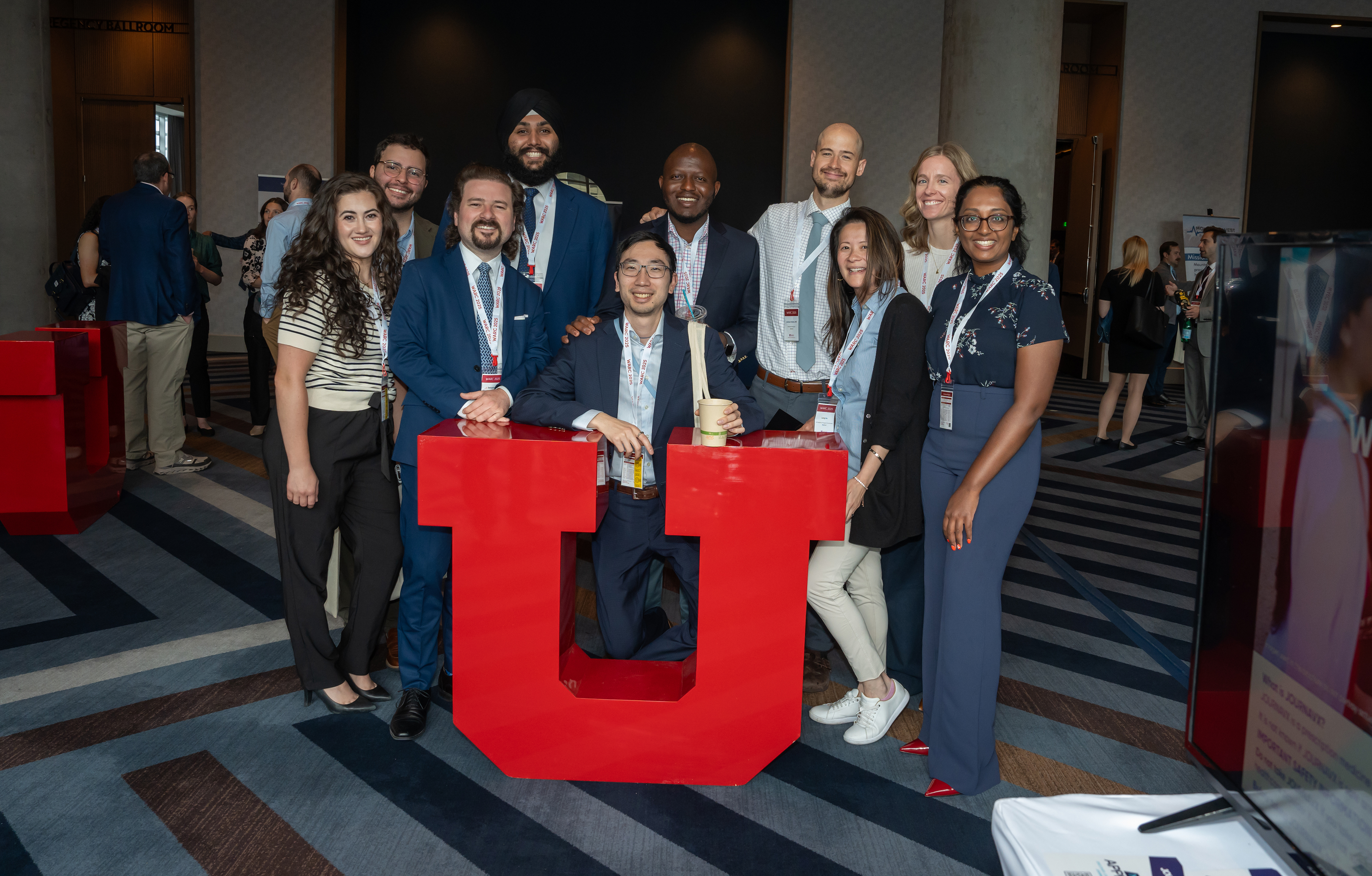 Residents pose behind a large red University of Utah “U”.