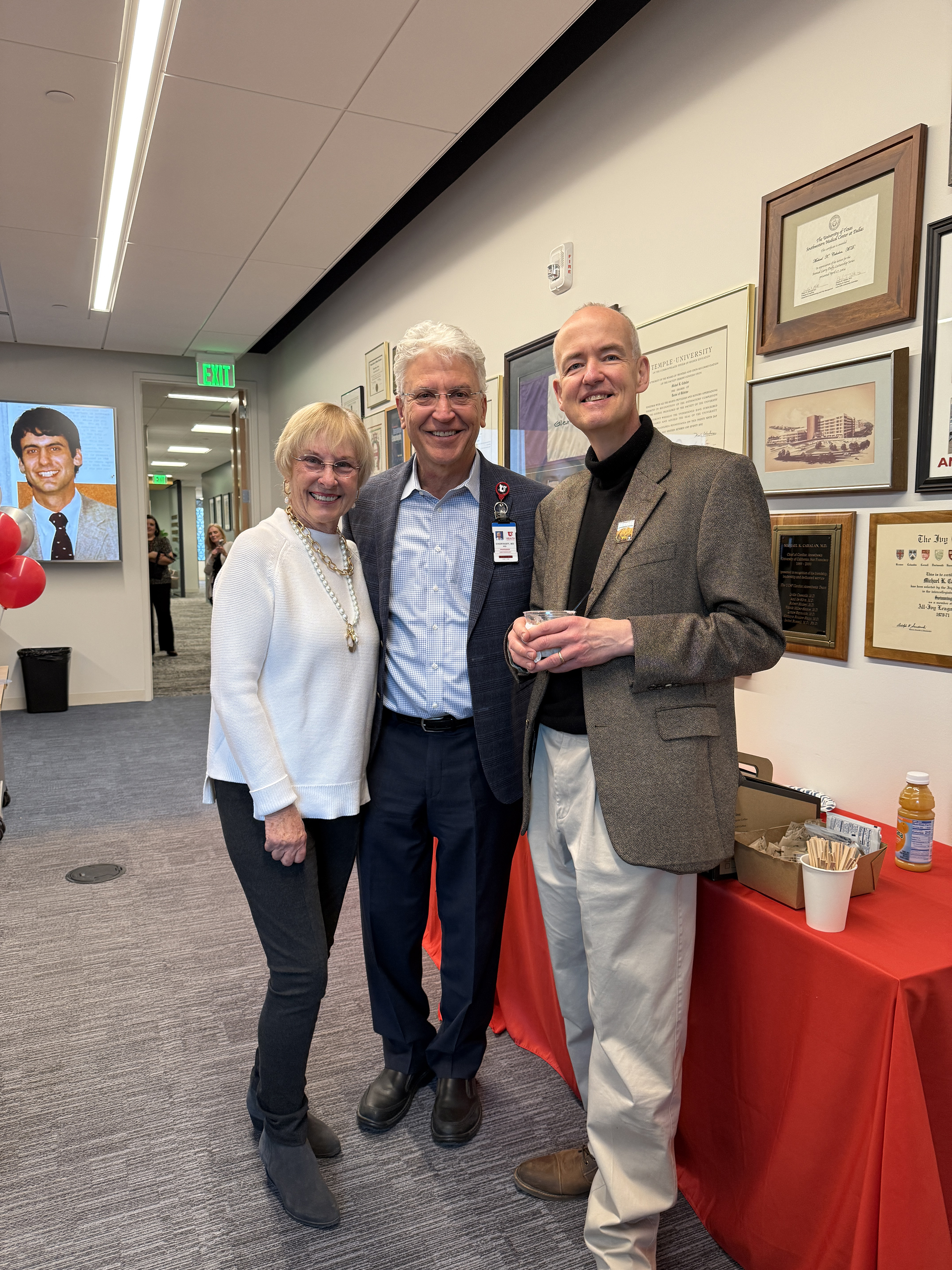 Marianne Cahalan, Dr. Ben Chortkoff, and Dr. Kai Kuck smiling for a photo in the Michael K Cahalan MD Conference Room. 
