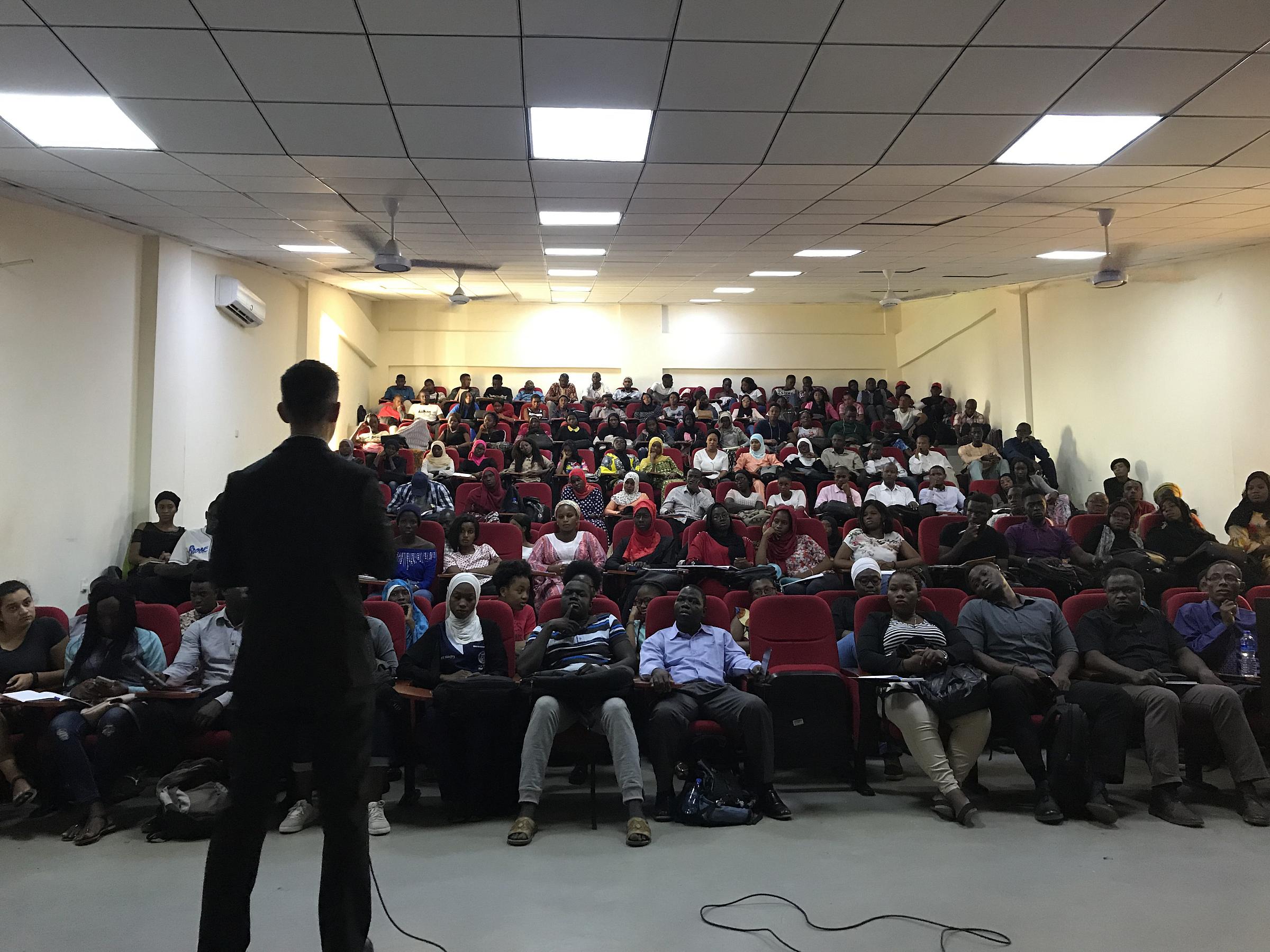 A doctor from U of U anesthesiology giving a presentation in a theater to a large group of students at AIUWA.