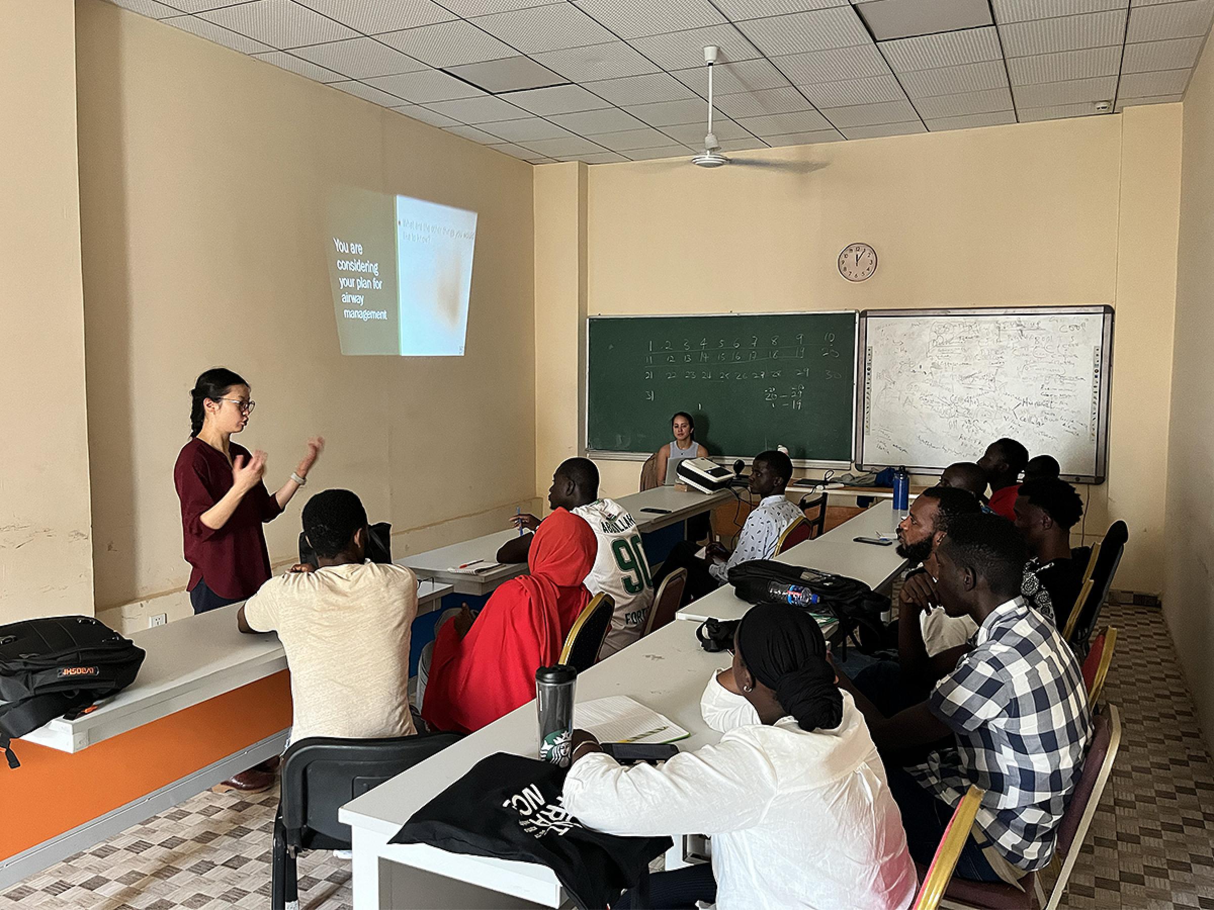A resident teaching a workshop on airway management in a classroom of 11 people.