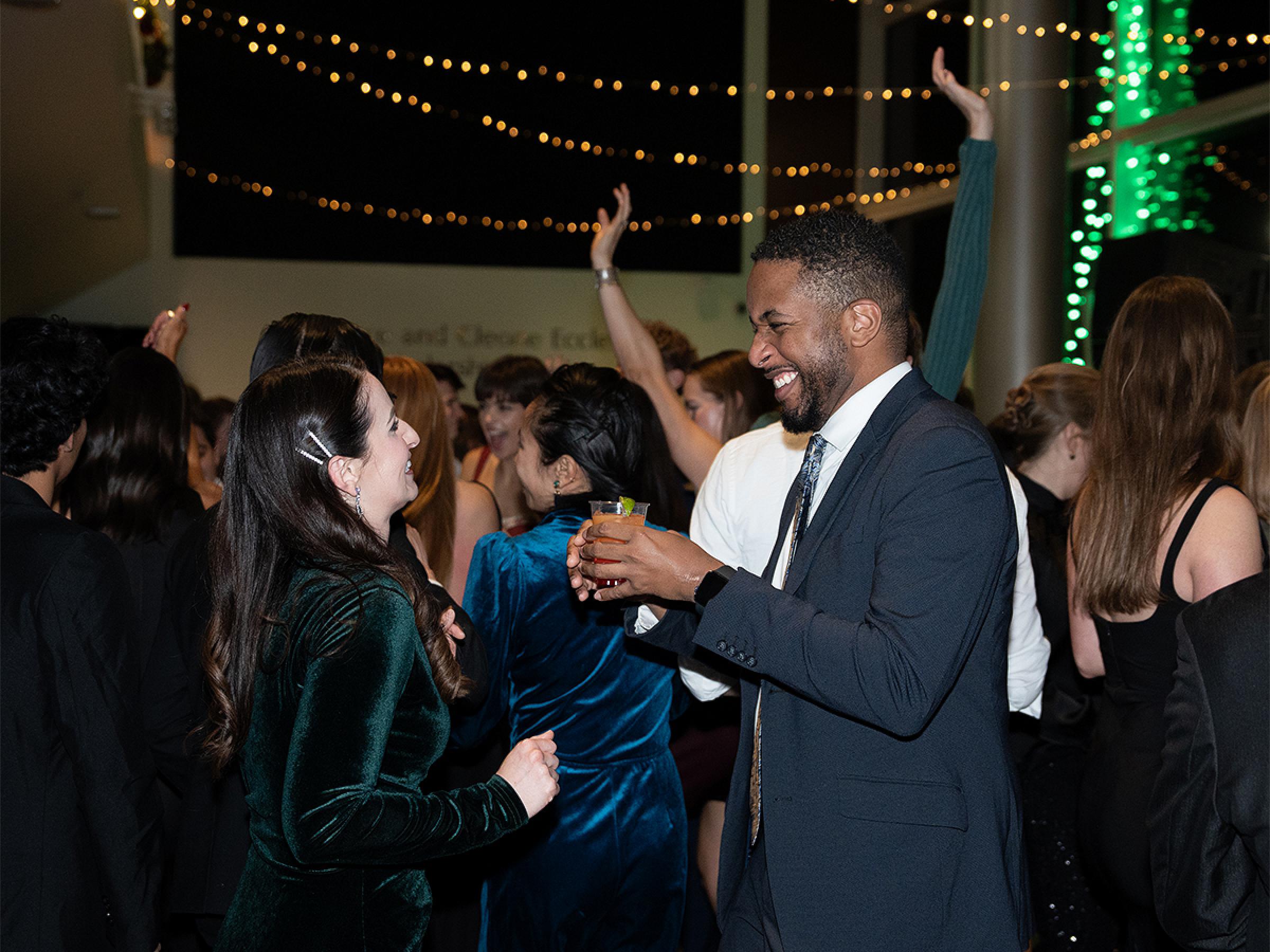 Two people smiling on the dance floor, dancing together.