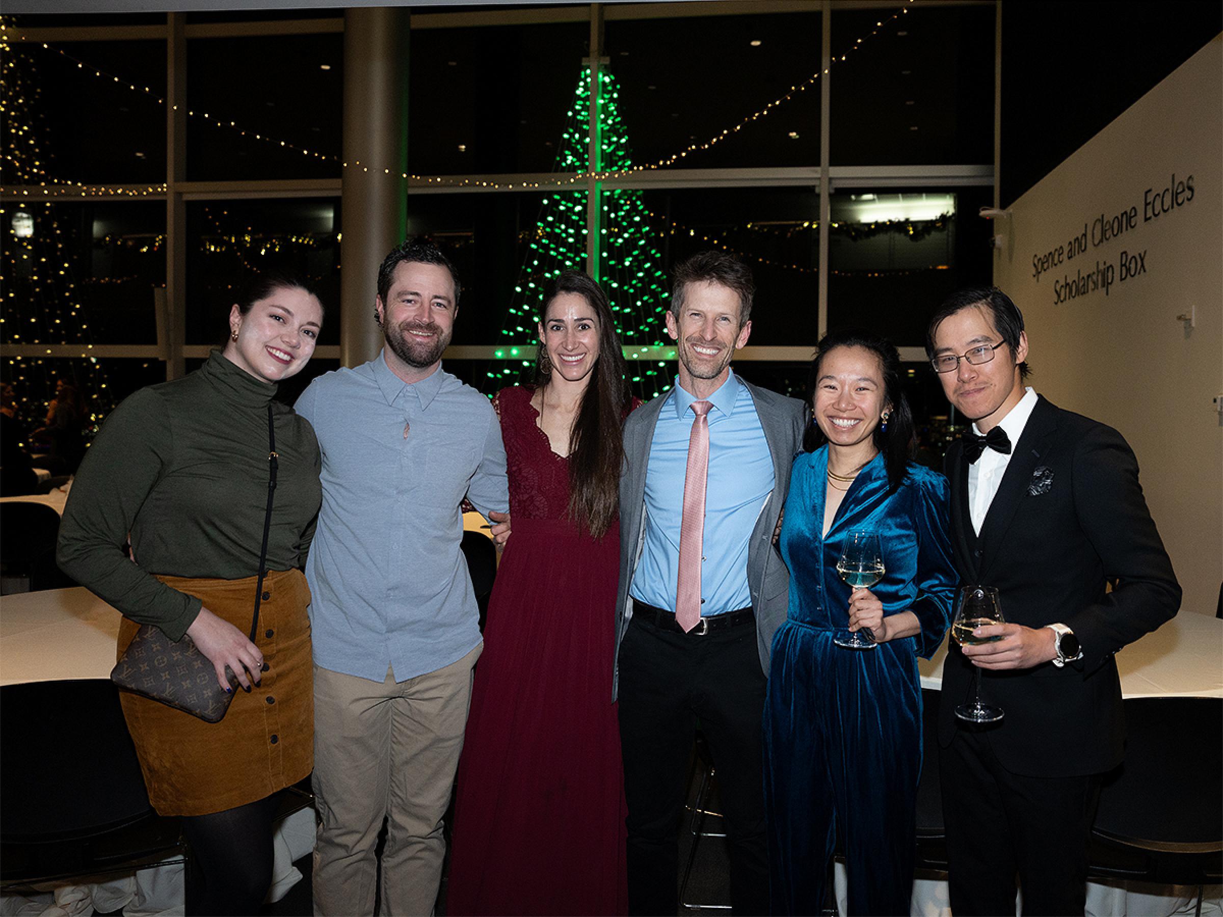 Six people standing together for a photo at the holiday party.