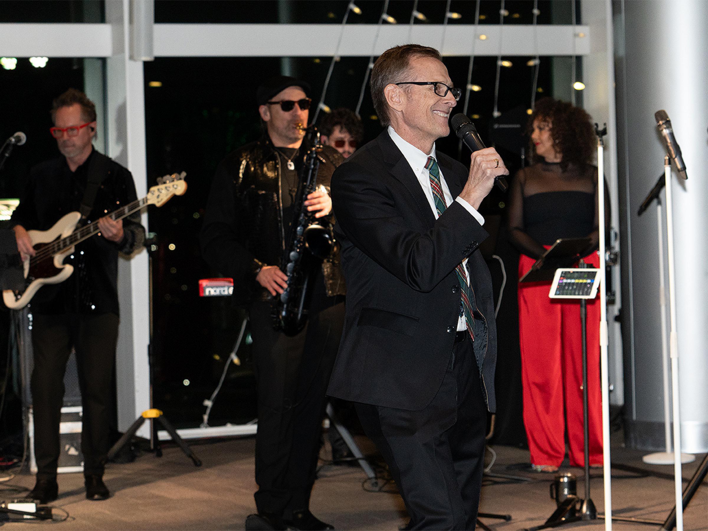 The department chair singing on the dance floor accompanied by the band. 