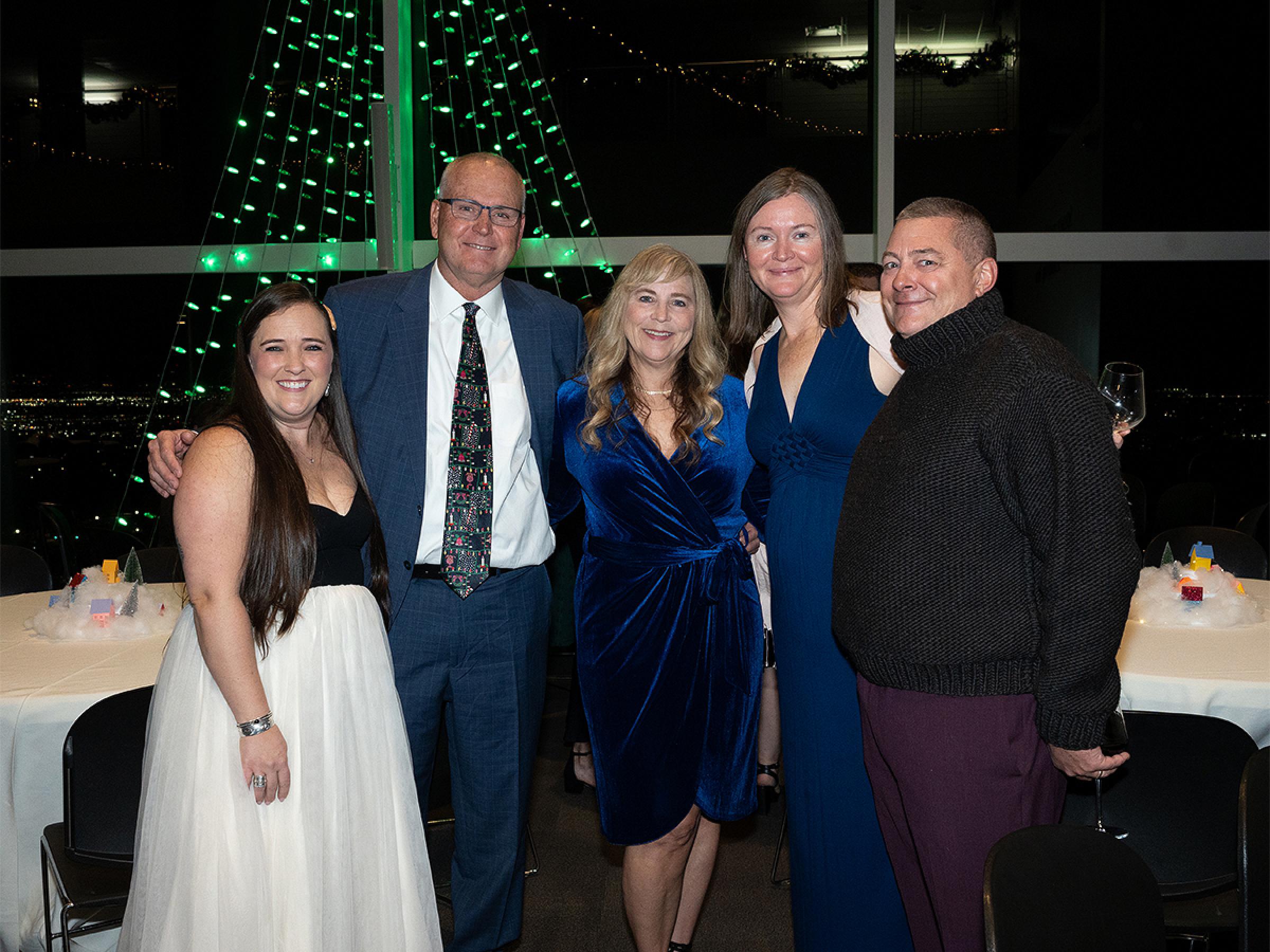 Five people standing together for a photo. 