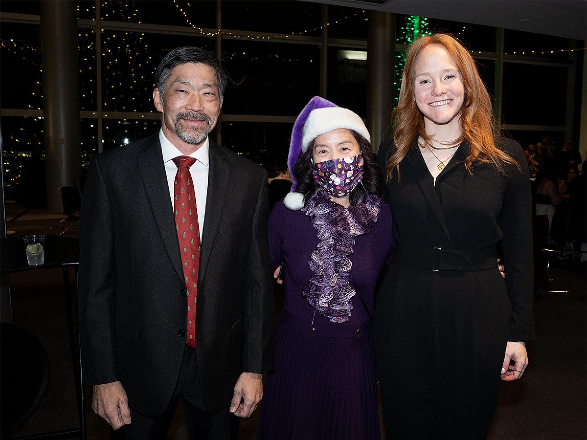 Three people standing together for a photo. 