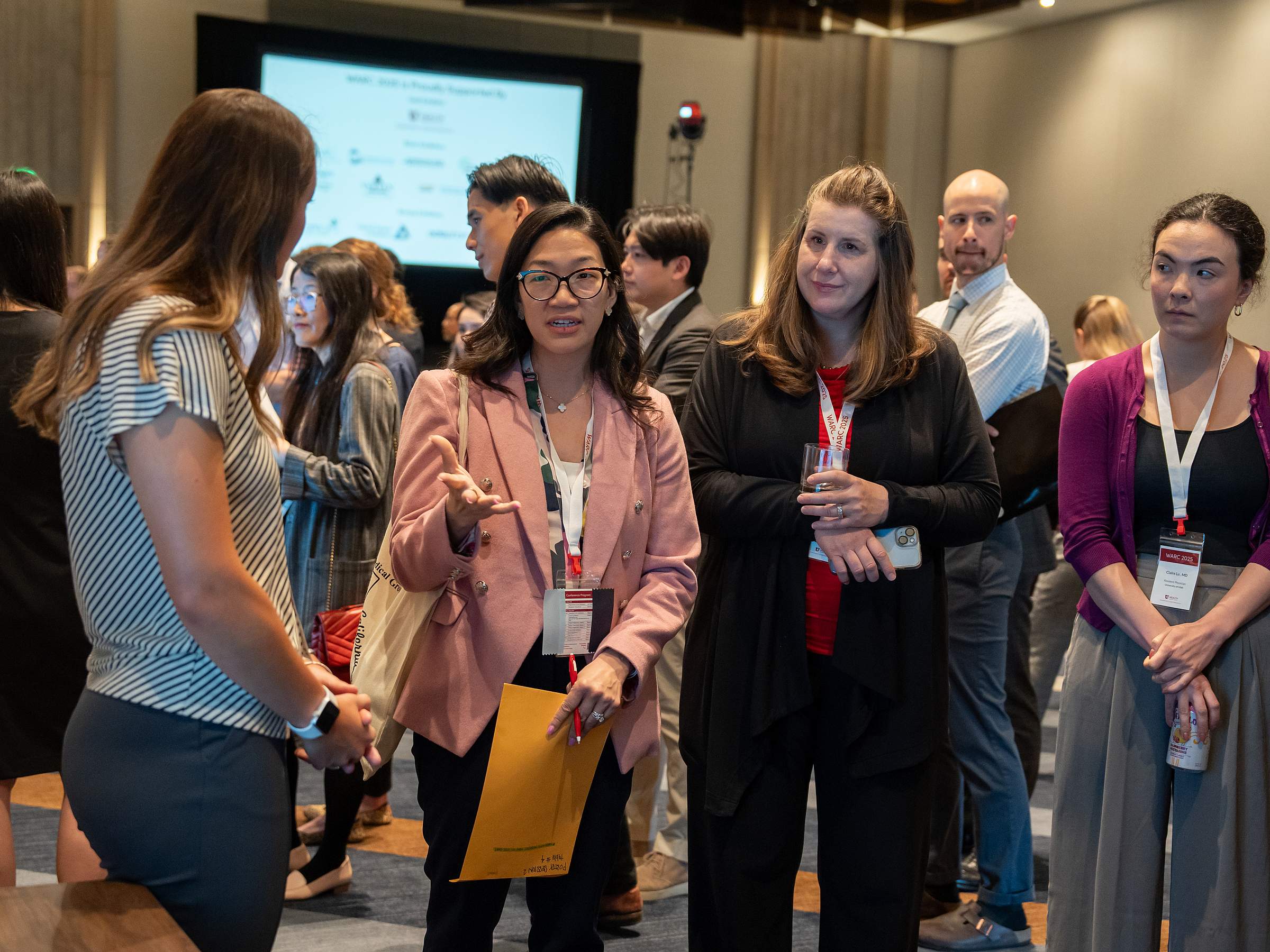 Residents interact with judges during a poster presentation session.