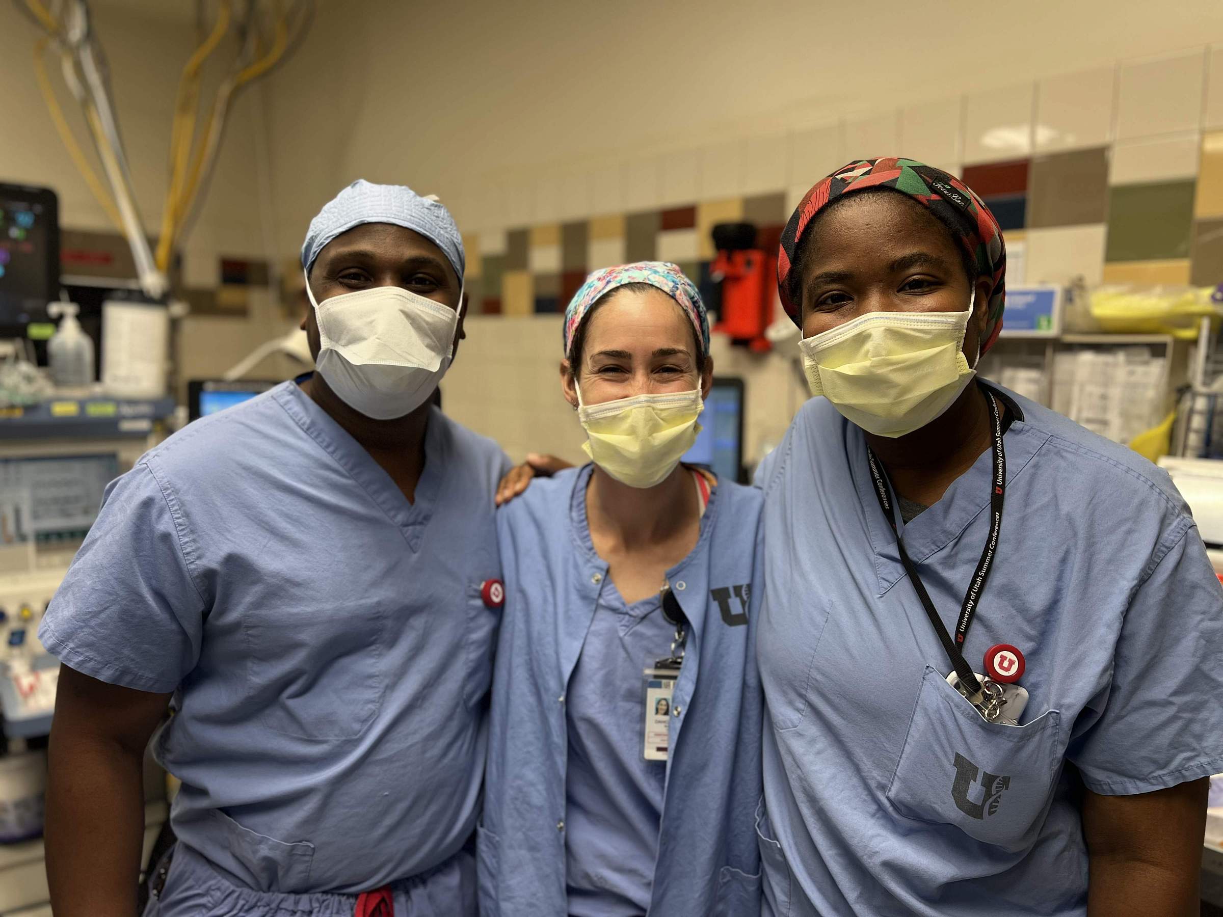Two USTARS students with a doctor in an operating room.