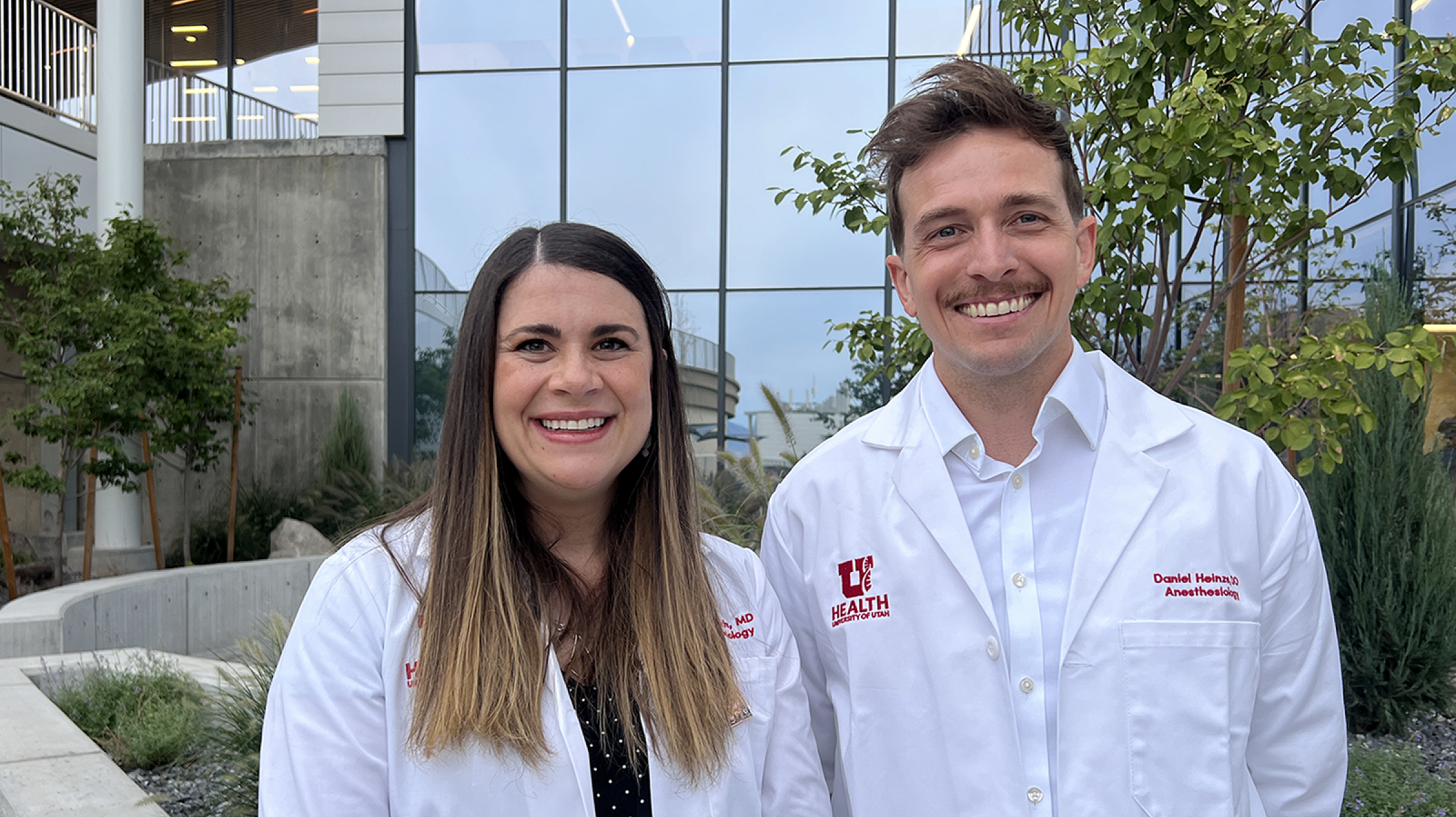 Dr. Rich and Dr. Heinze standing outside of the HELIX building smiling for a photo.