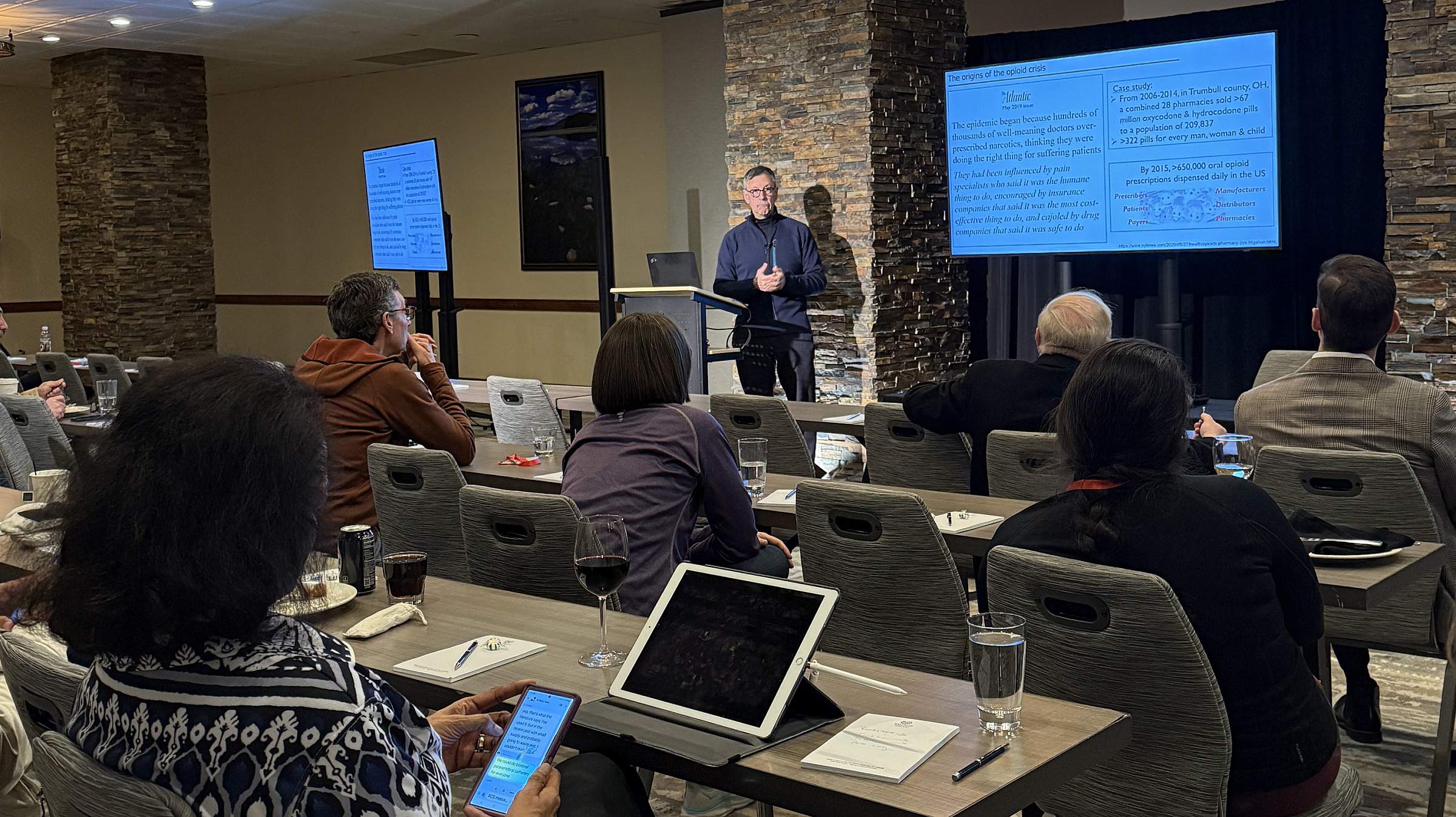 A presenter at the postgrad conference in front of a screen