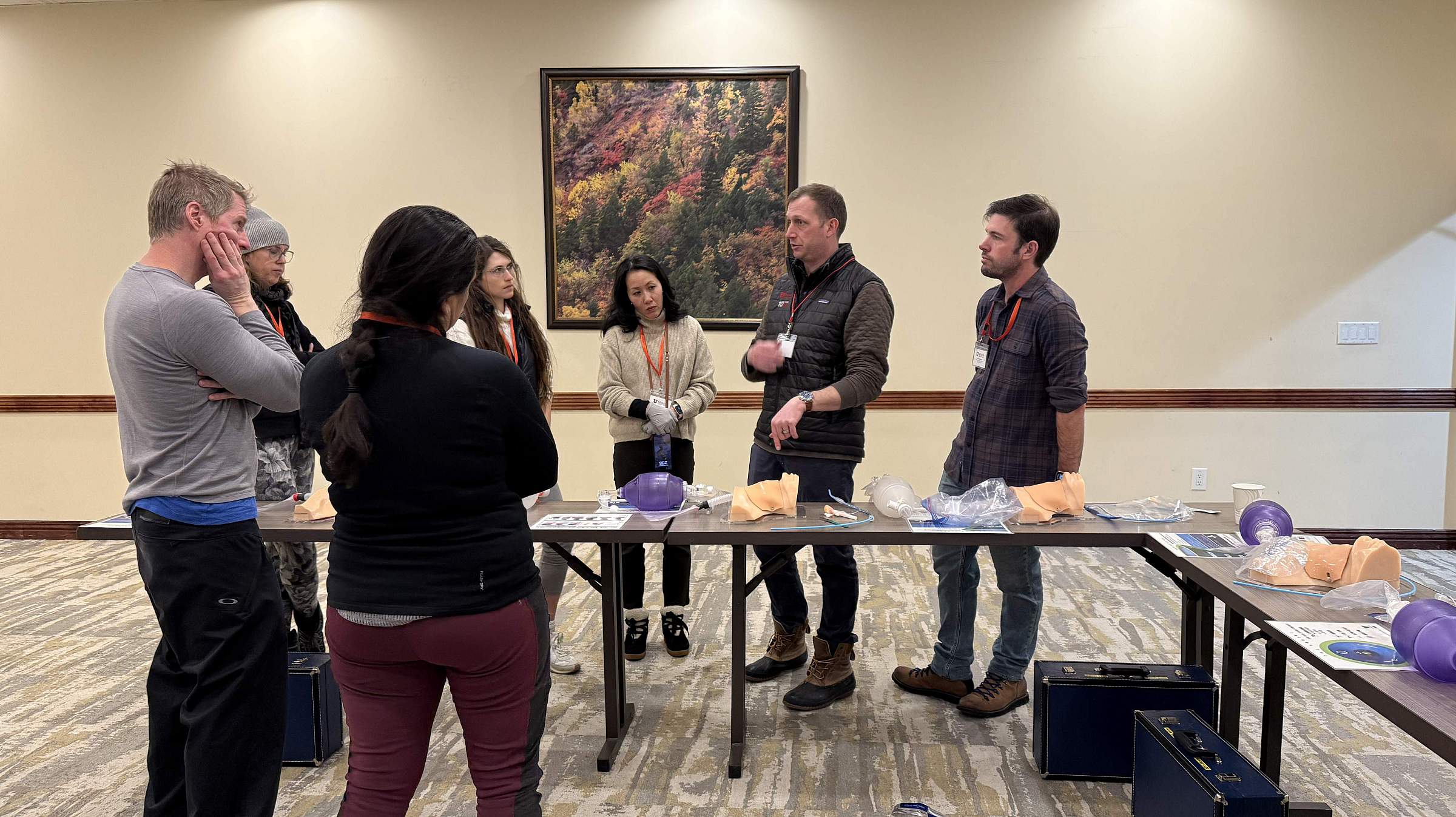 An instructor guides a group of 6 through a difficult airway workshop in a conference room.