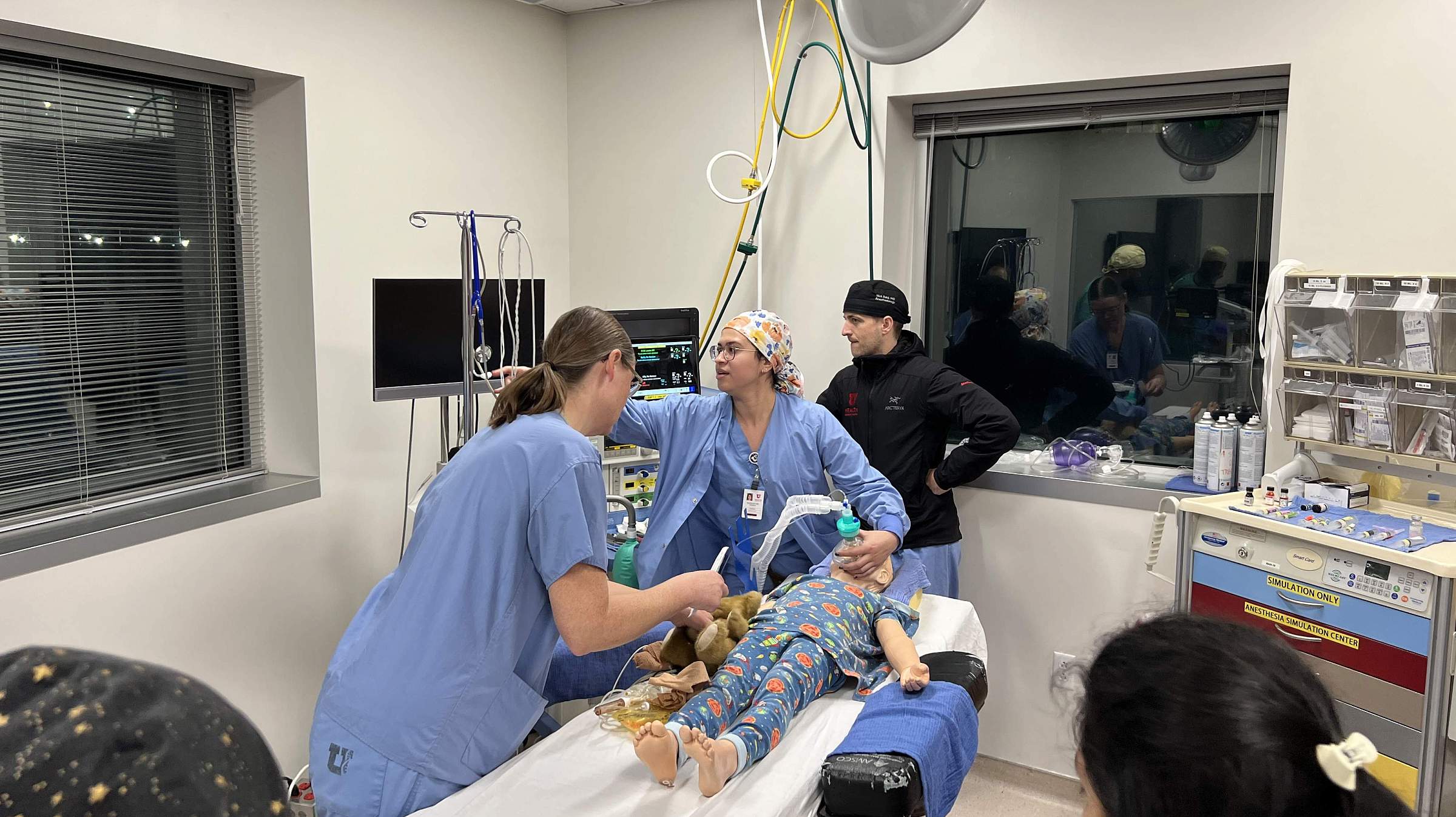 Doctors in a simulated intensive care unit with a child-sized mannequin patient