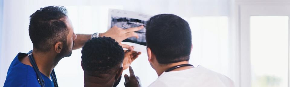three persons looks at x-ray result