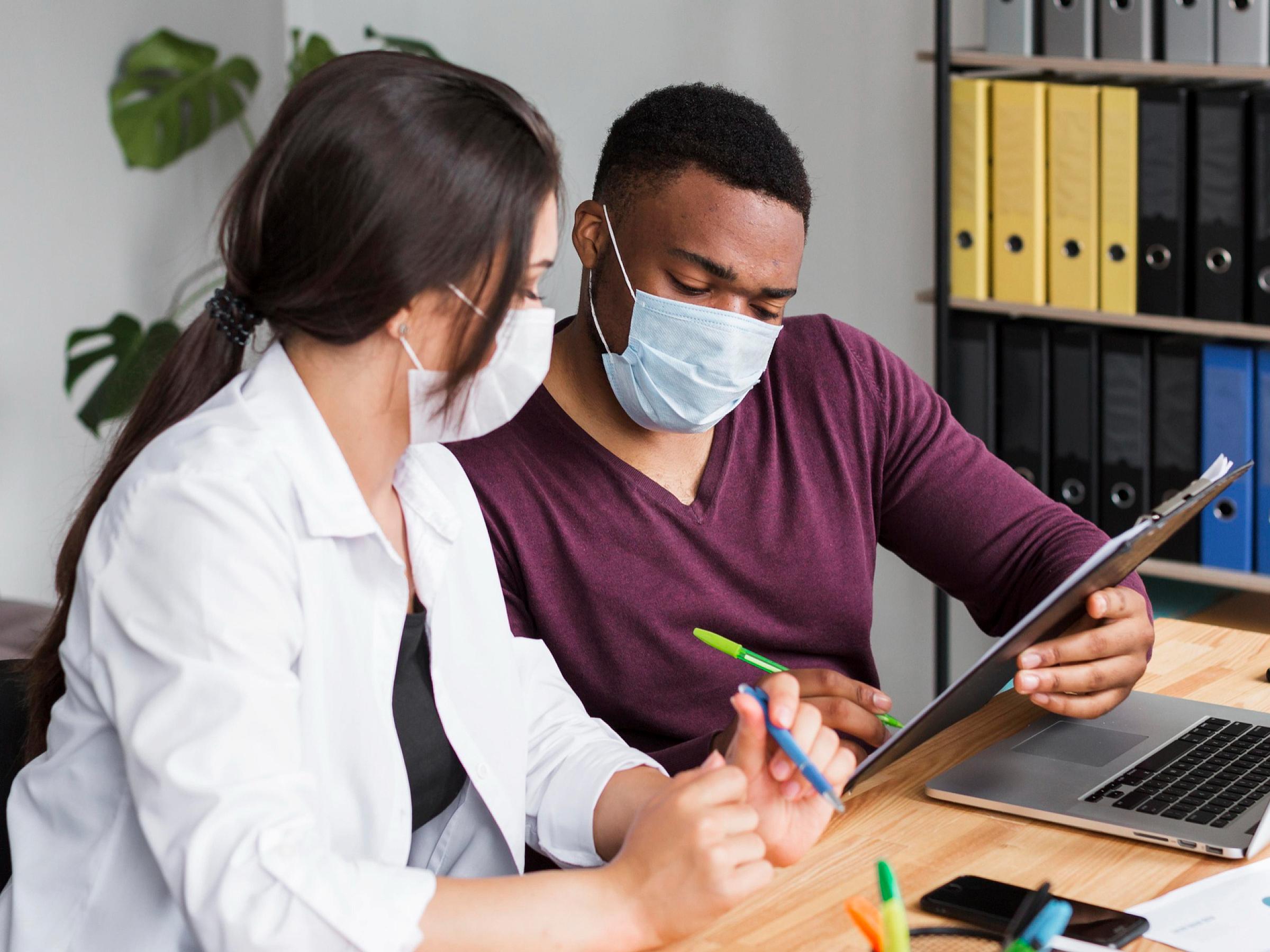 two medical professionals are working together at a desk